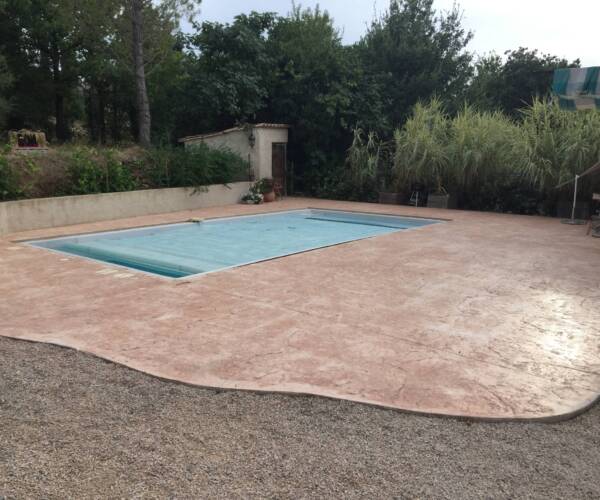 Contour de piscine posé par un spécialiste du béton imprimé à Avignon, finition bois antidérapante.