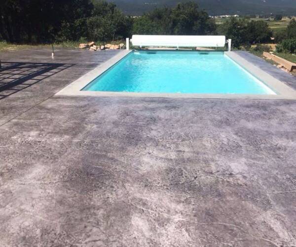 Plage de piscine posée par un spécialiste du béton imprimé à Brignoles, finition bois antidérapante.